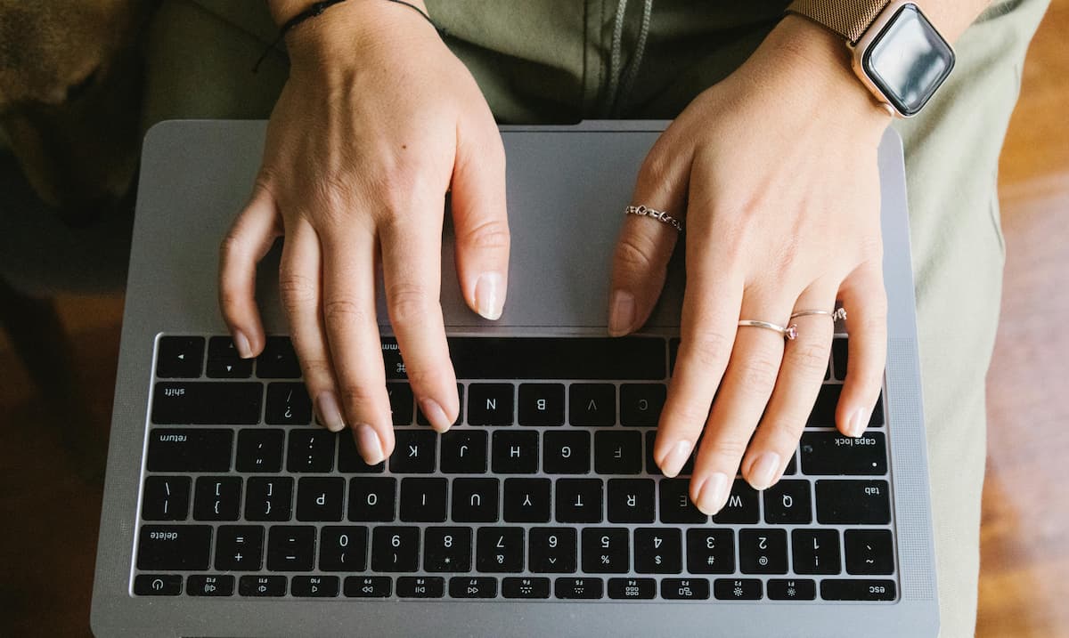 Feminine hands working on laptop.